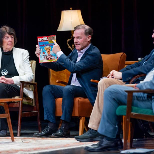 Gernot Bauer mit profil Cover aus 1986 auf einer Bühne