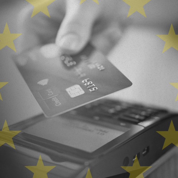 Eine Hand hält eine Bankkarte an den Kartenleser. Im Hintergrund sind die gelben Sterne der EU-Flagge zu sehen
