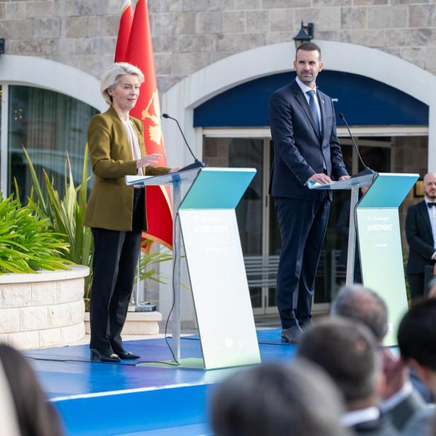 Ursula von der Leyen und  Milojko Spajić (Premier Montenegros) stehen auf einem Podium vor einer Montenegro-Flagge.