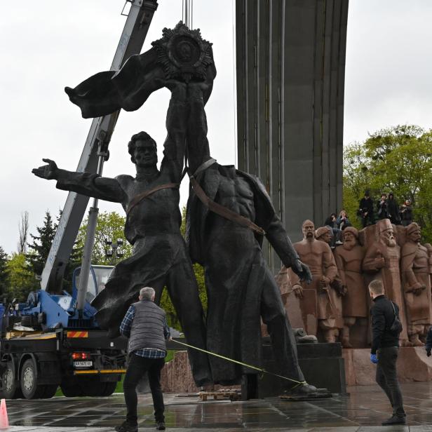 Arbeiter zerstören das Denkmal der russisch-ukrainischen Freundschaft im Jahr 2022 in Kyiv.
