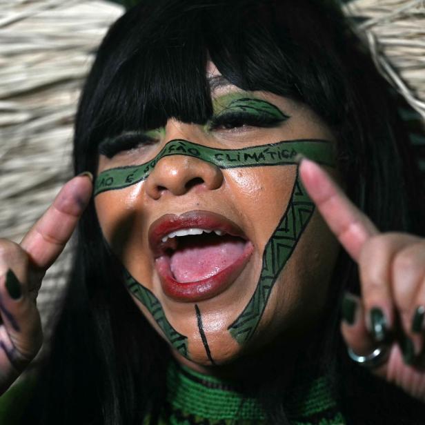 Die Indigene Celia Xakriaba mit Gesichtsbemalung und Schriftzug