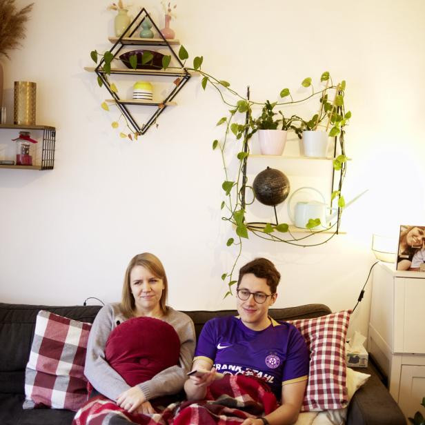 Long-Covid-Betroffene Dini und Lukas auf der Couch im Wohnzimmer