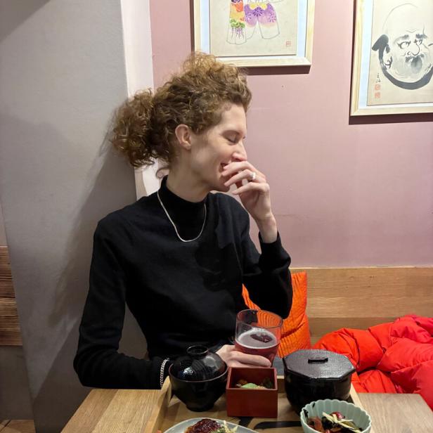 Schauspielerin Julia Riedler sitzt hinter einem japanischen Mittagsteller und blickt zur Seite