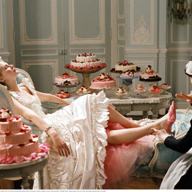 Filmstill aus "Marie Antoinette" - die Titelheldin sitzt auf einer Chaiselonge zwischen mehreren üppigen Cremetorten