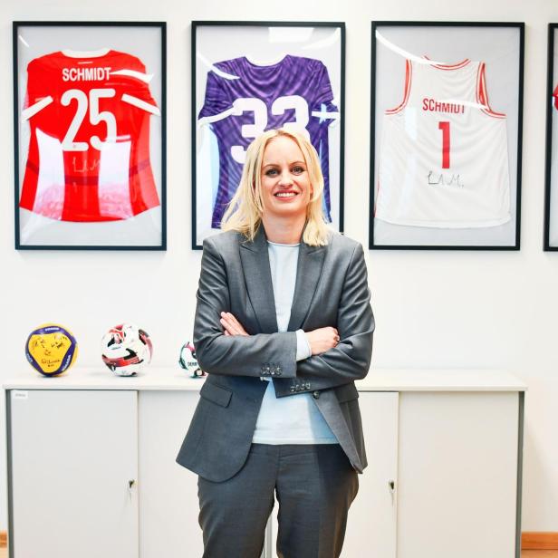 Staatssekretärin Michaela Schmidt und Regierungskoordinatorin steht vor einer Wand mit Sporttrikots