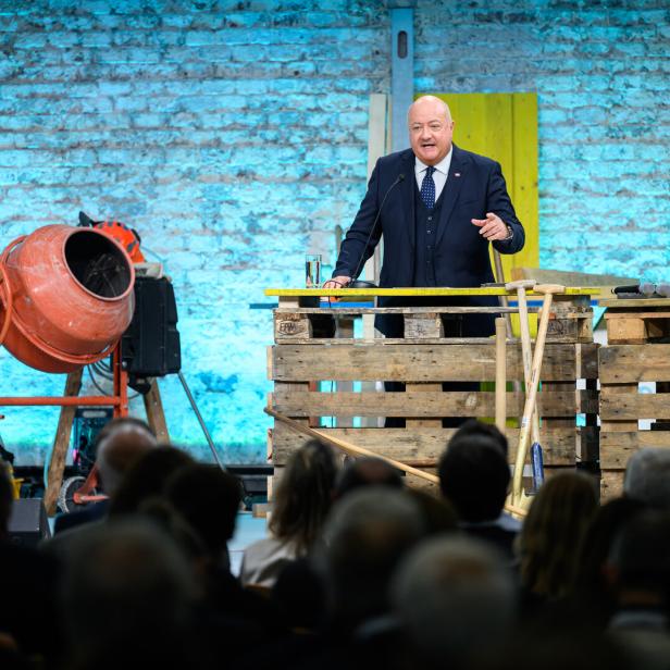 Ein Mann, es ist Bundeskanzler Stocker, steht auf einer Bühne und spricht.