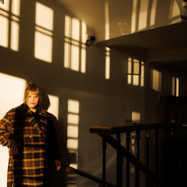 Stefanie Reinsperger steht in einem Treppenhaus