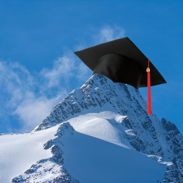 Schneebedeckter Berggipfel mit schwarzer Doktorhut-Mütze und rotem Quast.