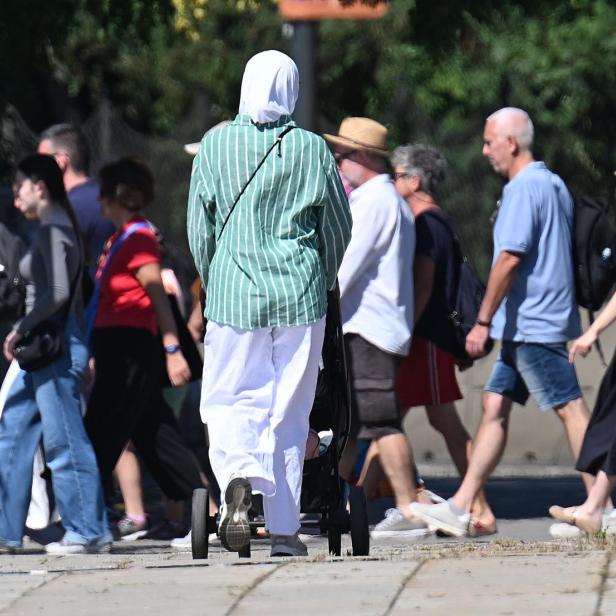 Frau in Kopftuch mit Kinderwagen