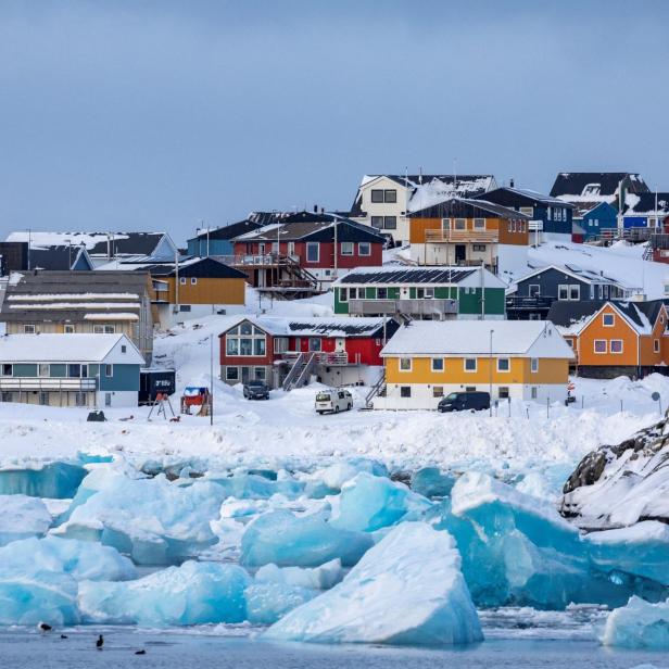 Im Vordergrund ist Eis zu sehen, im Hintergrund farbige Häuser der grönländischen Hauptstadt Nuuk.