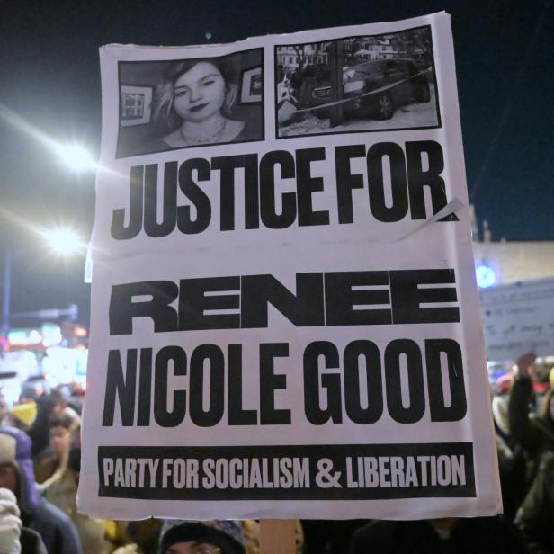 Auf einem Plakat steht: "Gerechtigkeit für Renee Nicole Good" in English, im Hintergrund sind Demonstrierende zu sehen.