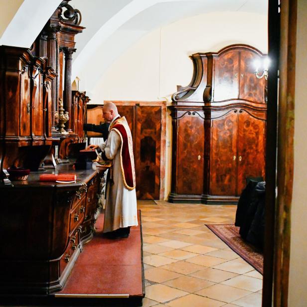 Ein Priester steht vor der Sakristei in der Wiener Paulanerkirche