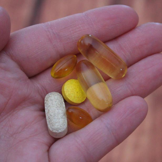 Person, die Medikamententabletten in der Hand hält
