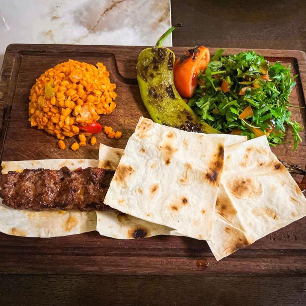 Ali Kebap mit Bulgur, gegrillter Tomate, gegrillter Paprika, Lavas-Brot und Salat