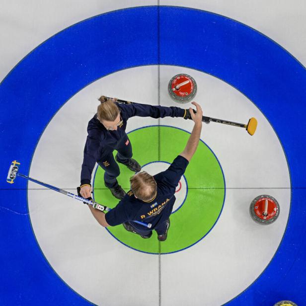 schwedisches Curling-Duo Isabella und Rasmus Wranå steht am Eis und ist kurz davor, sich zu umarmen