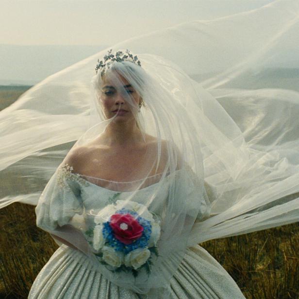 Die Schauspielerin Margot Robbie im weißen, vom Wind aufgewirbelten Brautkleid 