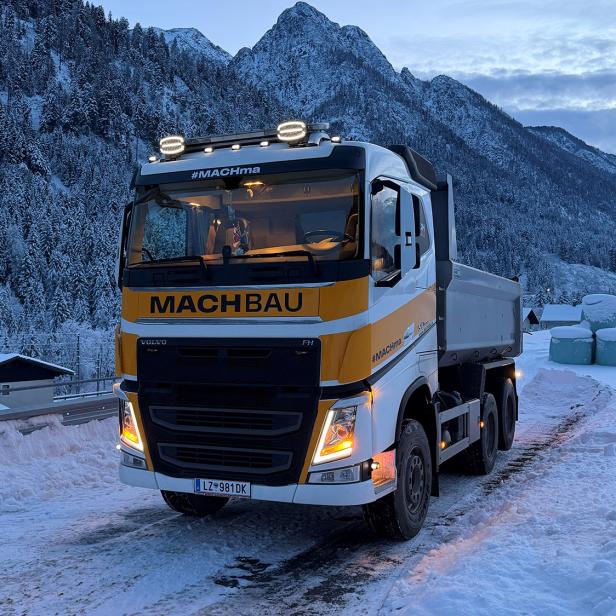 Lastwagen der MACHBAU GmbH auf verschneiter Straße vor winterlicher Bergkulisse in Osttirol.