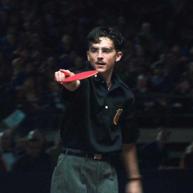 Timothée Chalamet mit Tischtennisschläger in einem abgedunkelten Raum
