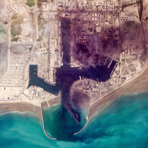 Ein Satellitenbild der saudischen Öl-Raffinerie Ras Tanrua. Schwarze Rauchschwaden steigen von der Anlage auf.