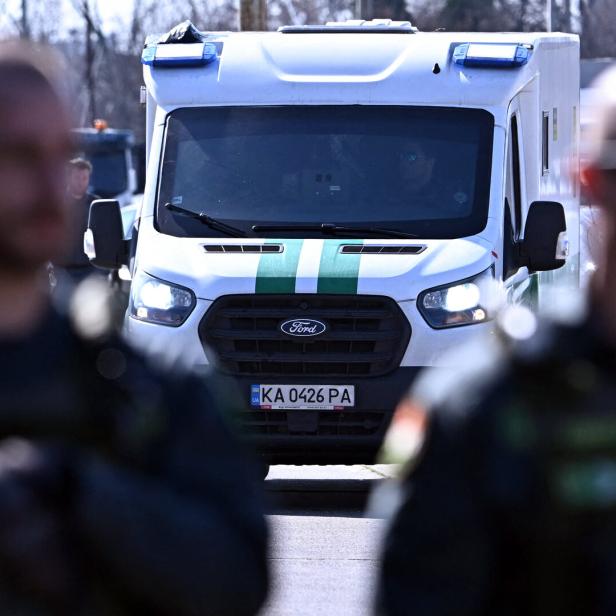 Ein konfiszierter Geldtransporter, im Vordergrund zwei uniformierte Männer. 