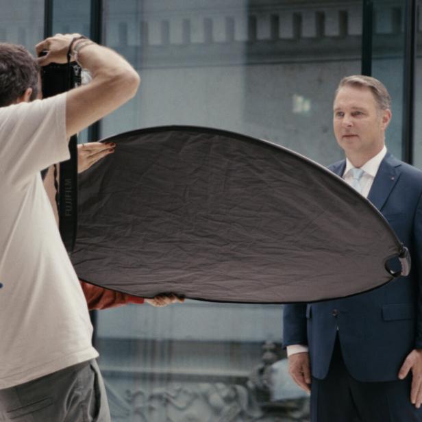 Andreas Babler im dunklen Anzug vor der Kamera eines Fotografen