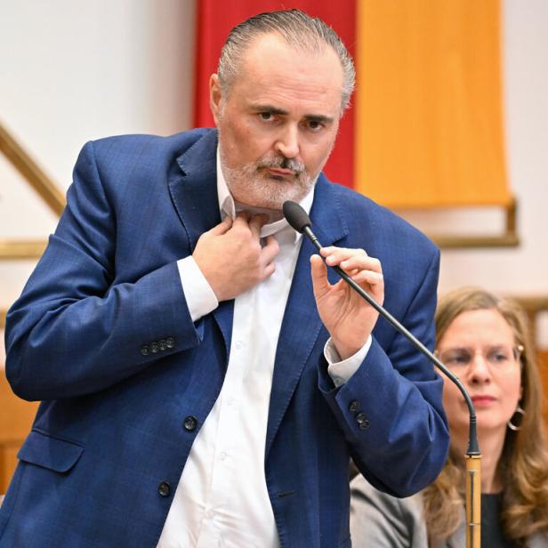 Doskozil im Landtag, während einer Rede hält er sich die Operationsstelle am Hals mit den Fingern zu