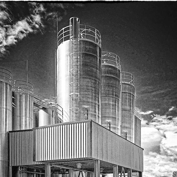 Ein schwarz-weiß Bild von Silo-Lagerstationen einer Industriestätte.