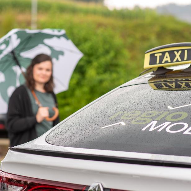 Eine Frau steigt in das Regio Mobil bei Regen ein