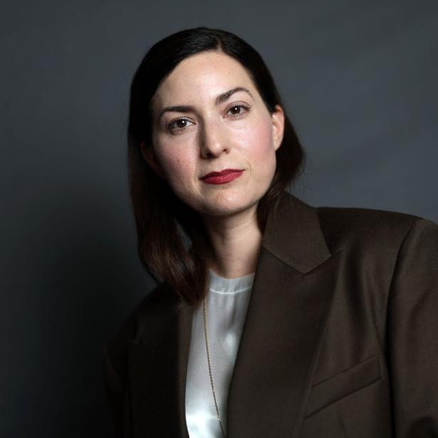 Regisseurin Rebecca Zlotowski blickt vor grau-neutralem Hintergrund direkt in die Kamera