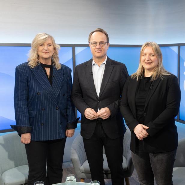 Drei Personen stehen vor einem Bildschirm mit der Aufschrift 'SPONTAN GEFRAGT' in einem Fernsehstudio
