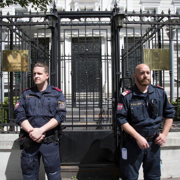 Zwei Polizisten stehen vor dem Gatter der russischen Botschaft in Wien.