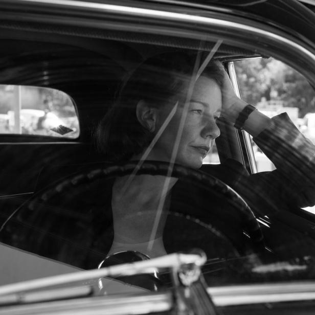 Schwarzweißes Bild der Schauspielerin Sandra Hülle, die in einem Auto sitzt und versunken nach draußen blickt