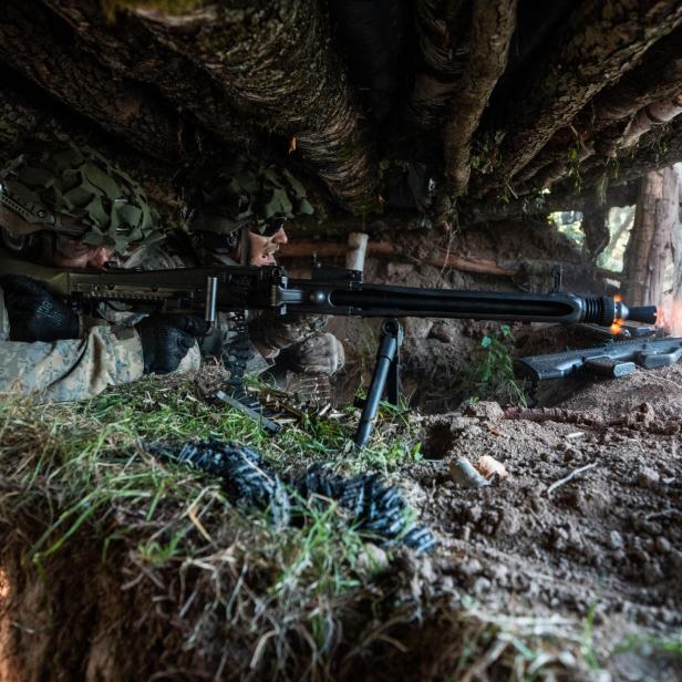 Soldaten schießen mit einem Maschinengewehr