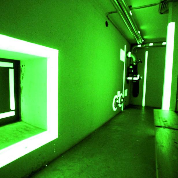 Grüne Leuchtfarbe erhellt den dunklen Bunker.