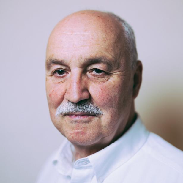 Porträt des Theologen Wolfgang Palaver vor neutralem, grau-weißem Hintergrund 