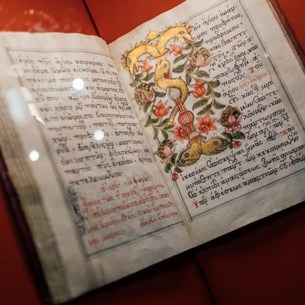 Geöffnetes altes Buch mit handgeschriebenem Text und farbiger floraler Illustration auf der rechten Seite