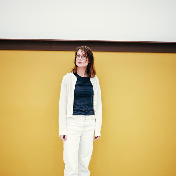 Fatima Hellberg, neue Direktorin am Mumok, vor gelb-weißer Wand, in schwarz-weißer Kleidung