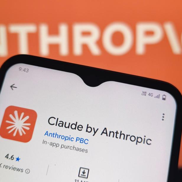 Ein Smartphone zeigt die App-Store-Seite für „Claude by Anthropic“ vor einem Hintergrund mit dem Anthropic-Logo.