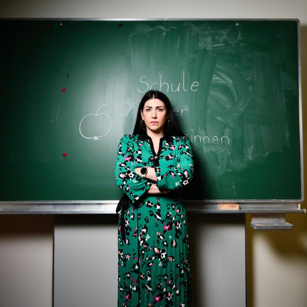 Die Wiener Volksschullehrerin Ilkay Idiskut steht vor einer grünen Schultafe 