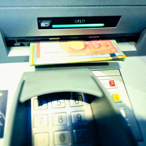 Bargeld am Bankomatenschlitz über der Tastatur, Nahaufnahme