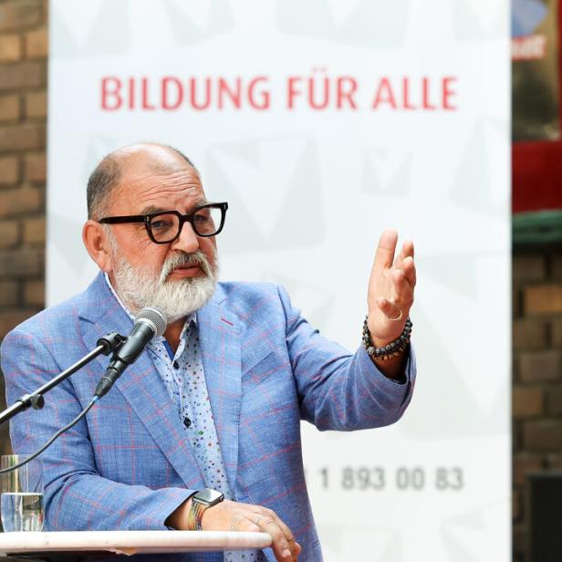 Herbert Schweiger vor einem Plakat der Volkshochschulen