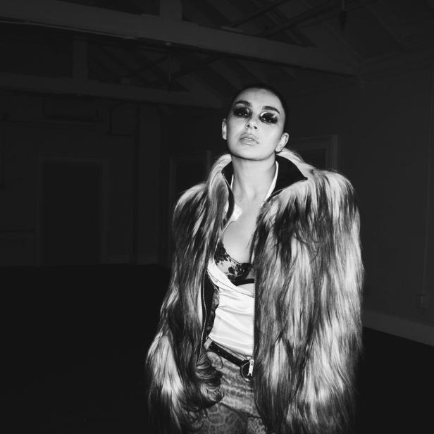 Die Musikerin Charli xcx in eienm schwarzweißen Foto, mit Sonnenbrillen und Pelzjacke