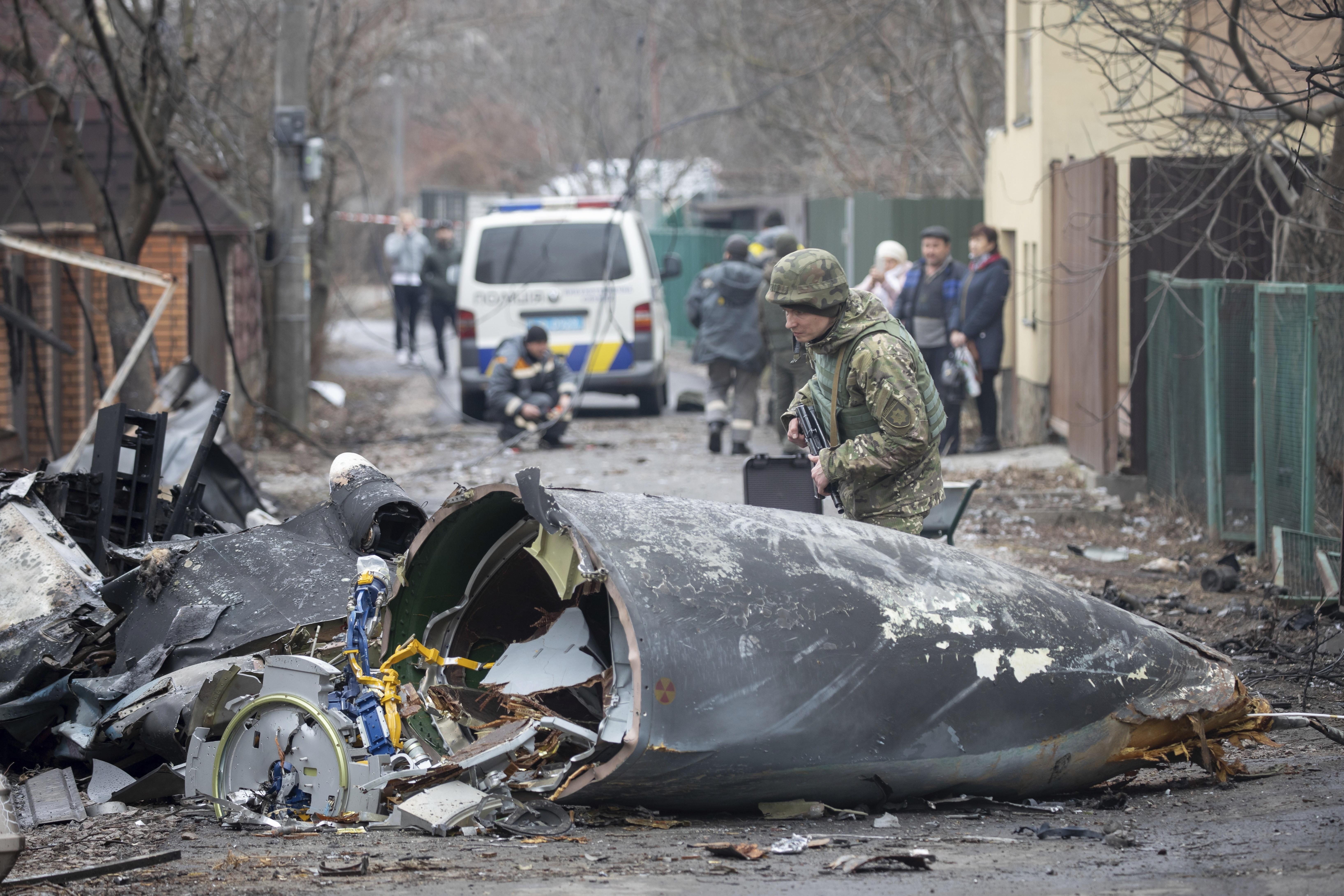 Ein Soldat der ukrainischen Armee inspiziert Fragmente eines abgeschossenen Flugzeugs in Kiew, Ukraine, Freitag, 25. Februar 2022.